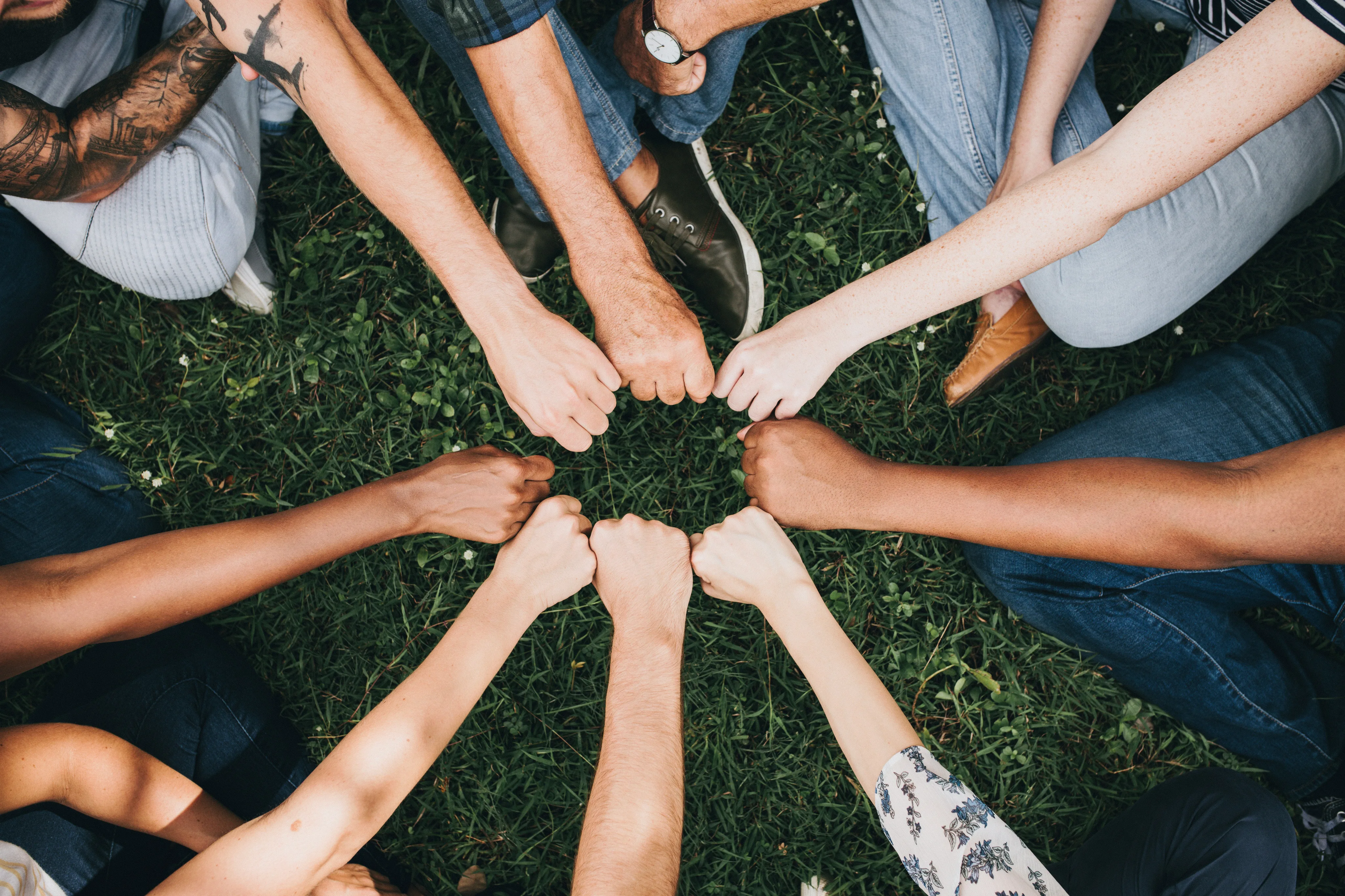 Hands joined together in a circle, showing community and belonging